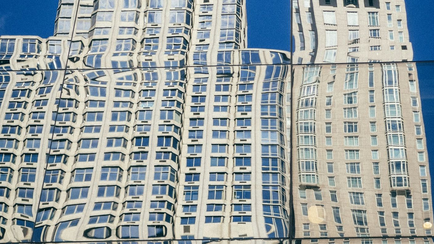 Building reflection warped by a curved glass facade, showing how fluent AI output can distort the facts underneath it