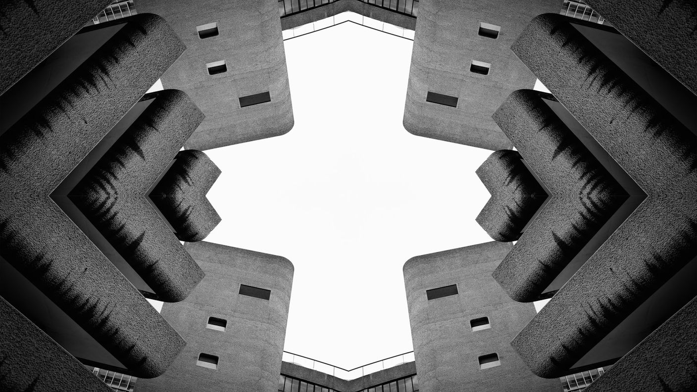 Symmetrical brutalist concrete structure with a stark gap at its center, echoing the missing reasoning layer in enterprise AI deployments